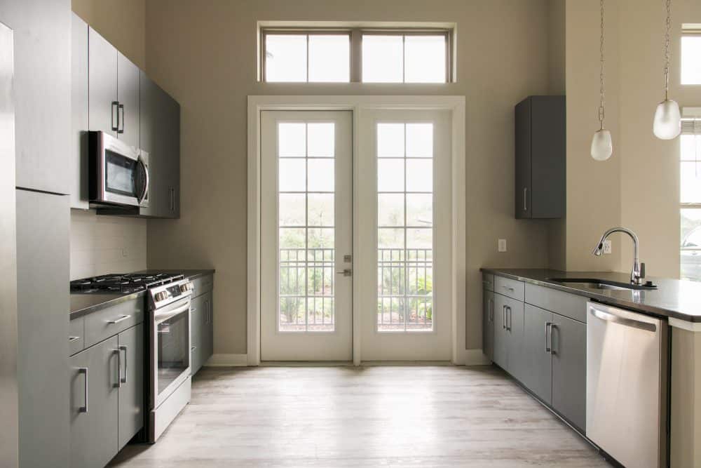 Interior apartment kitchen with stainless steel appliances and ample natural light